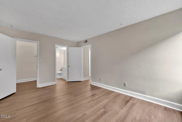 a view of an empty room with wooden floor