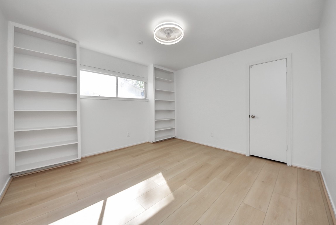 10719 Burgoyne Road Houston, TX 77042 - Photo 19 of 36 Bedroom #3 features a built-in shelf, a walk in closet, and updated ceiling fan lights recently installed by the owner.
