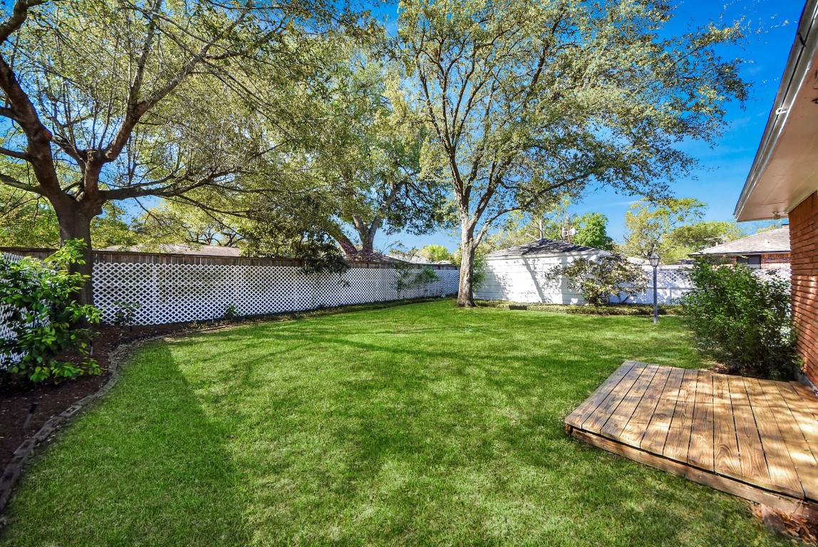 10719 Burgoyne Road Houston, TX 77042 - Photo 26 of 36 Beautiful backyard with a wood deck just outside the primary bedroom—perfect for enjoying your morning coffee.