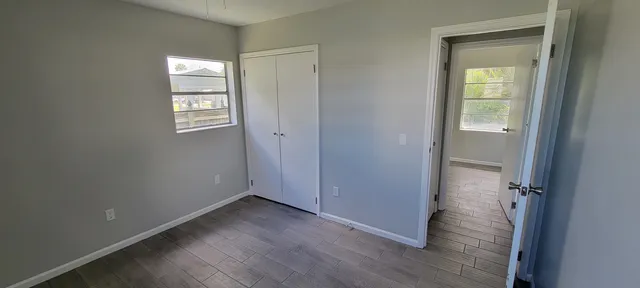 an empty room with windows and closet