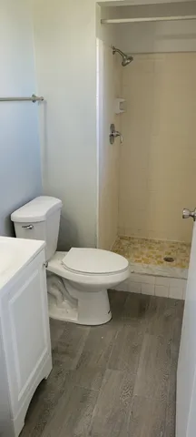 a bathroom with a toilet and a shower