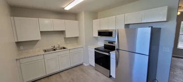 a kitchen with stainless steel appliances a refrigerator stove and sink