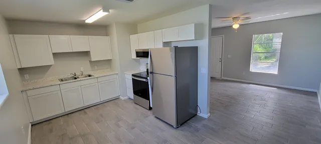a kitchen with stainless steel appliances a refrigerator sink and cabinets