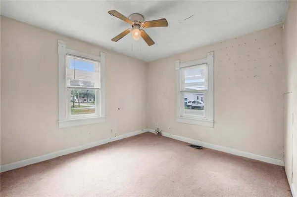 an empty room with chandelier fan