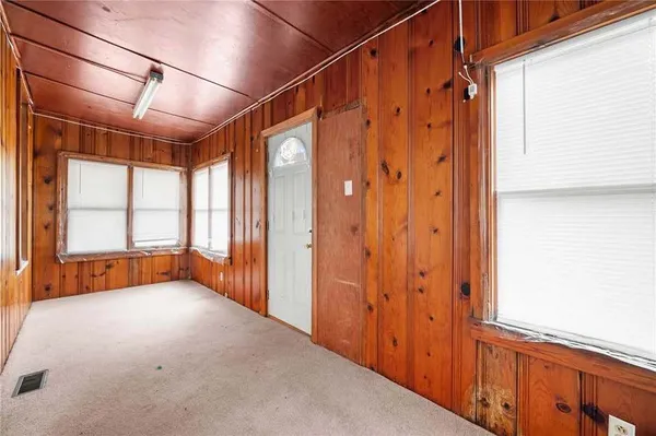 an empty room with fan and windows