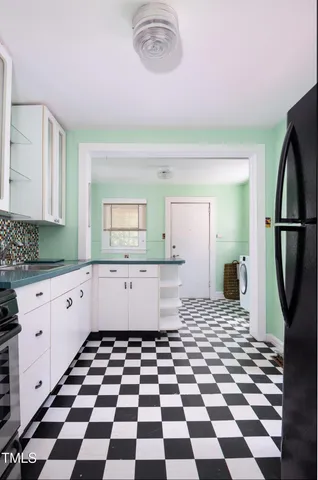 a kitchen with white cabinets and appliances