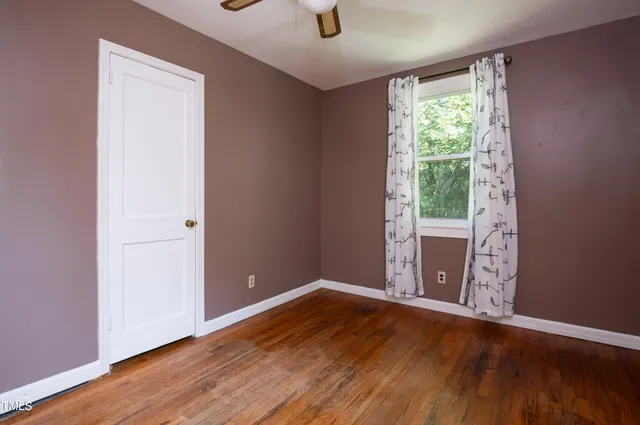 a view of room with window and wooden floor