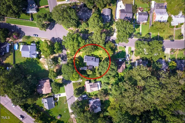 a view of an empty room with wooden floor fireplace and a window