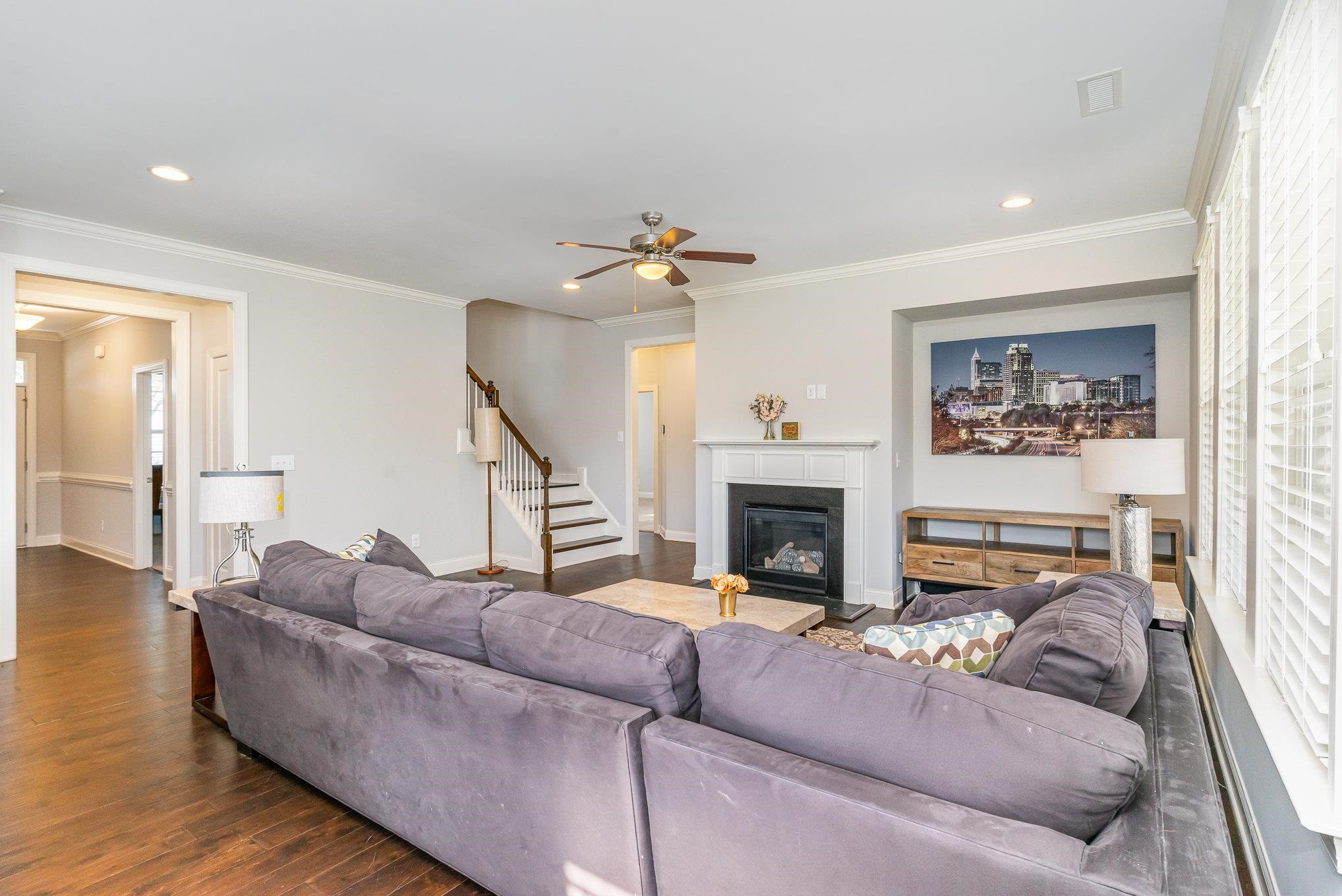 702 Chapanoke Road Raleigh, NC 27603 - Photo 12 of 39 a living room with furniture a fireplace and a ceiling fan