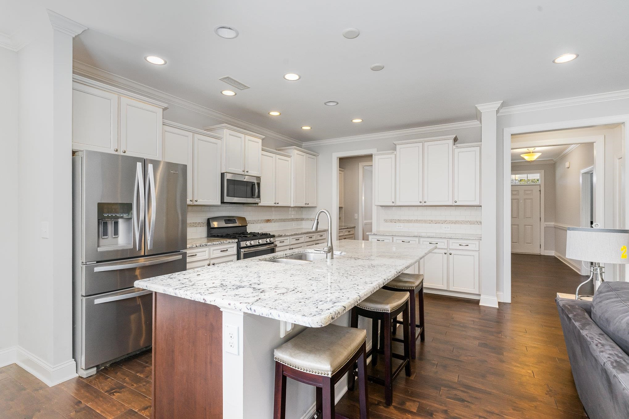 702 Chapanoke Road Raleigh, NC 27603 - Photo 9 of 39 a kitchen with stainless steel appliances granite countertop a refrigerator a stove top oven a sink dishwasher a dining table and chairs with wooden floor
