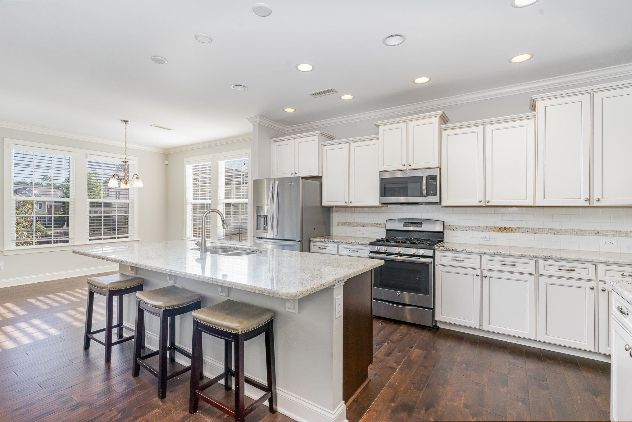 702 Chapanoke Road Raleigh, NC 27603 - Photo 10 of 39 a kitchen with stainless steel appliances granite countertop a stove top oven a sink dishwasher a dining table and chairs with wooden floor