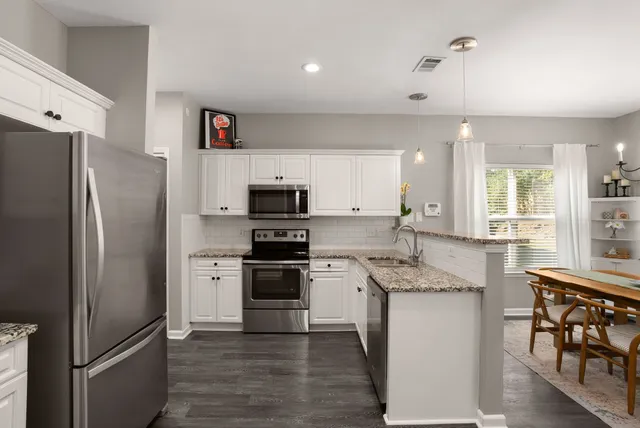 a kitchen with stainless steel appliances granite countertop a refrigerator stove and sink