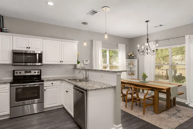 a kitchen with stainless steel appliances granite countertop a stove a sink and a refrigerator