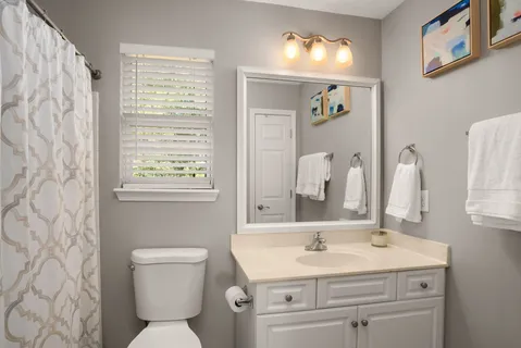 a bathroom with a toilet sink and mirror