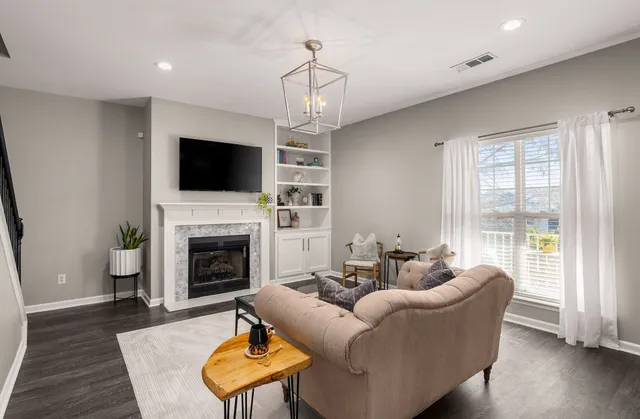 a living room with furniture a flat screen tv and a fireplace