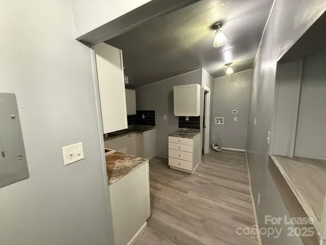 a view of a kitchen with furniture and wooden floor