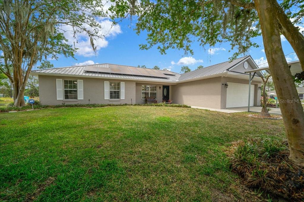 234 Locust Lane Ocala, FL 34472 - Photo 34 of 71 a white house with a small yard and large trees