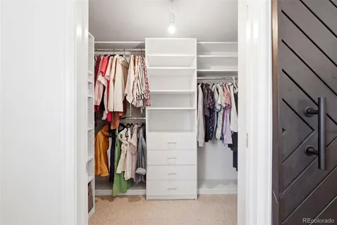 a view of walk in closet with clothes