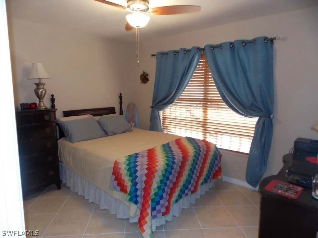16881 Davis Road, Unit 813 Fort Myers, FL 33908 - Photo 16 of 25 a bed sitting in a bedroom next to a window