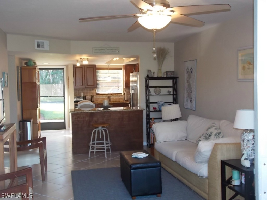 16881 Davis Road, Unit 813 Fort Myers, FL 33908 - Photo 8 of 25 a living room with furniture a chandelier and a dining table
