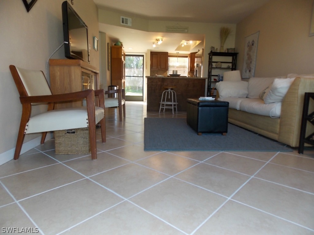 16881 Davis Road, Unit 813 Fort Myers, FL 33908 - Photo 9 of 25 a living room with furniture a dining table and a fireplace