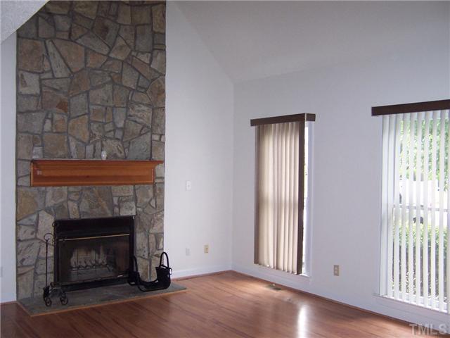 4513 Birmingham Way Raleigh, NC 27604 - Photo 3 of 8 a view of an empty room with wooden floor and a fireplace