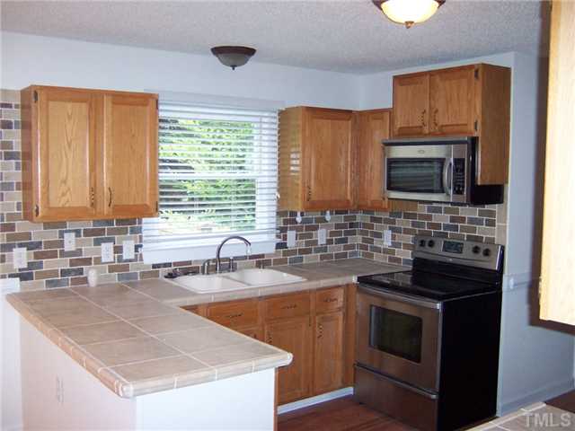 4513 Birmingham Way Raleigh, NC 27604 - Photo 5 of 8 a kitchen with stainless steel appliances granite countertop a sink stove and microwave