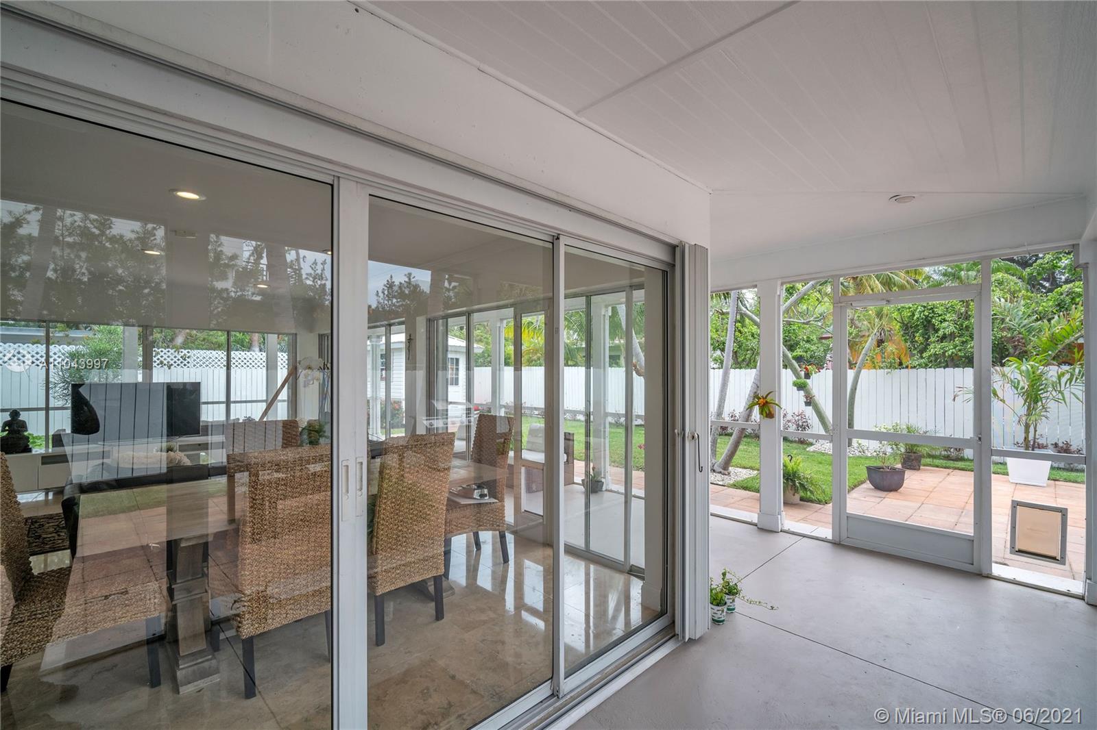 774 Fernwood Road Key Biscayne, FL 33149 - Photo 13 of 36 a room with patio furniture and a dining table with garden view