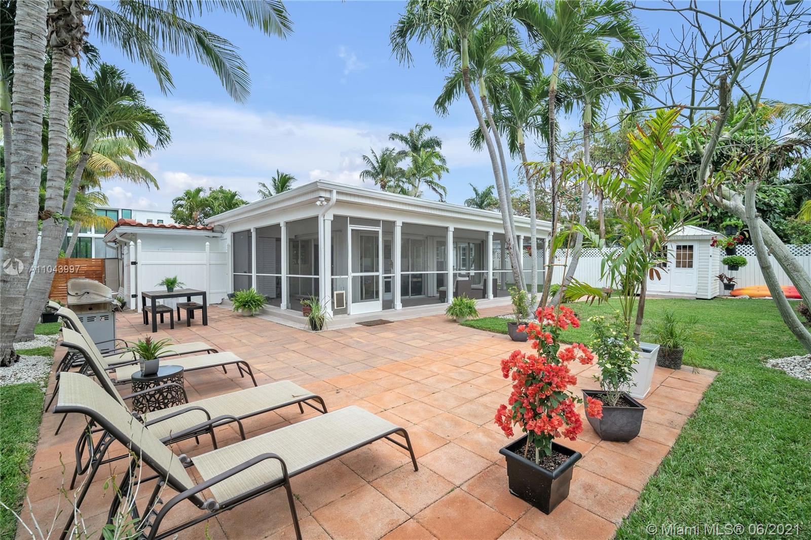 774 Fernwood Road Key Biscayne, FL 33149 - Photo 3 of 36 a view of a house with backyard sitting area and garden