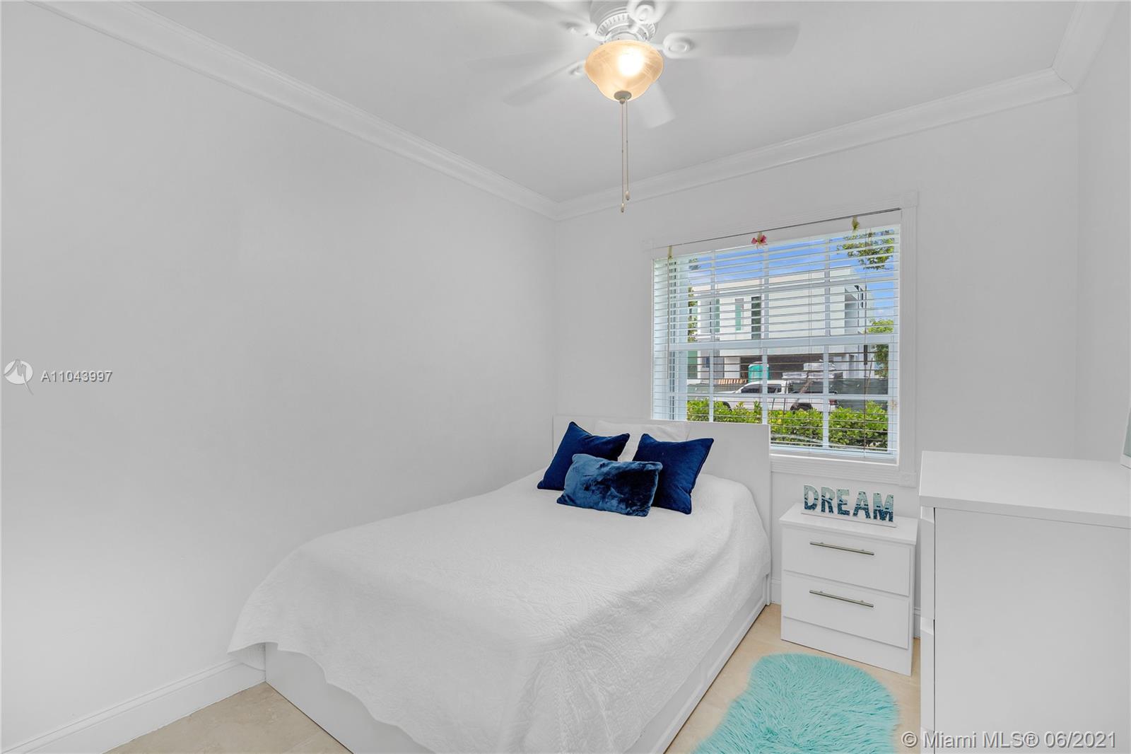 774 Fernwood Road Key Biscayne, FL 33149 - Photo 29 of 36 a bedroom with a bed a chandelier and a window