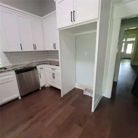 an empty room with wooden floor cabinet and view