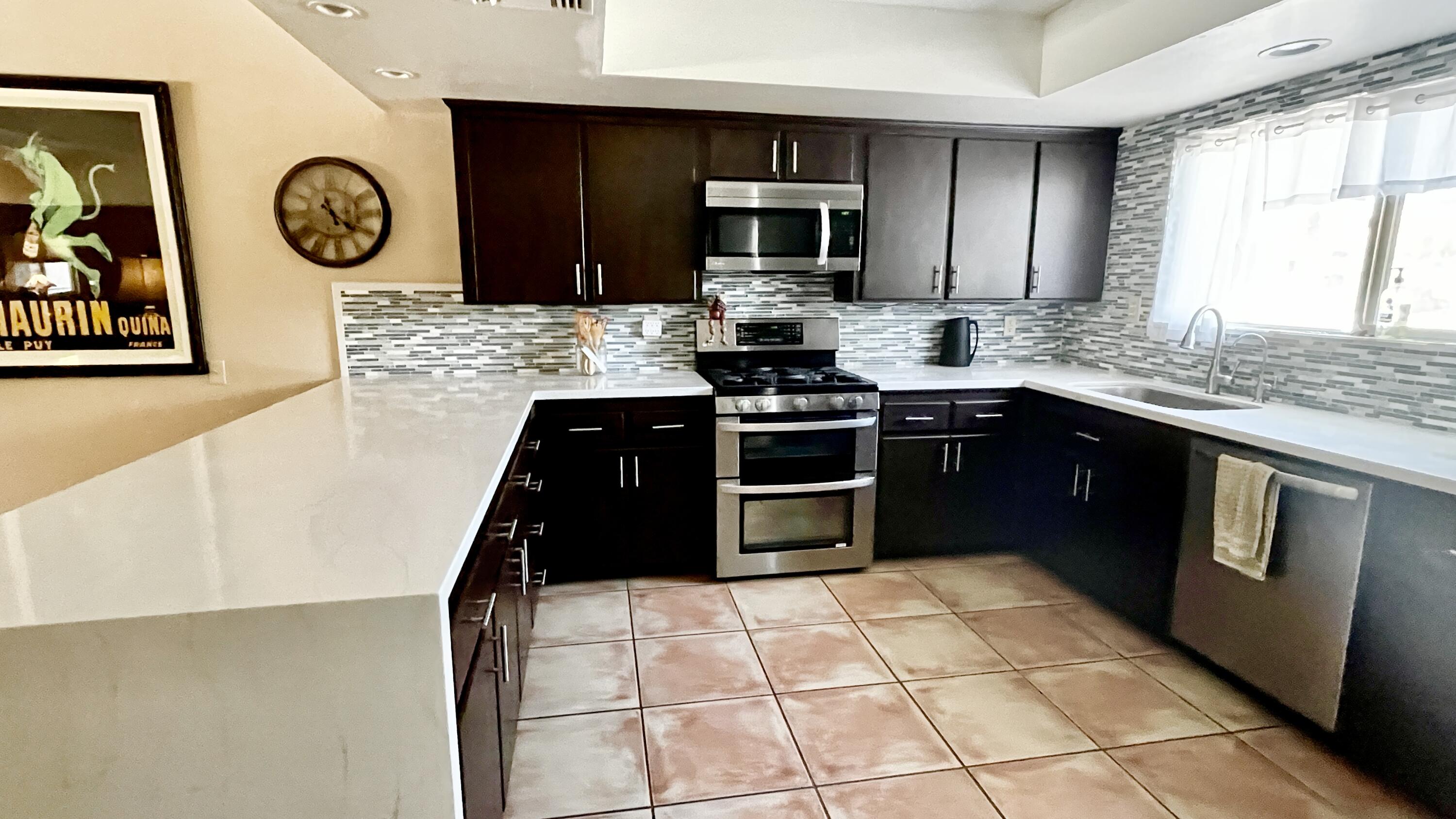 2775 East Verona Road Palm Springs, CA 92262 - Photo 3 of 10 a kitchen with stainless steel appliances granite countertop a stove a sink and a microwave