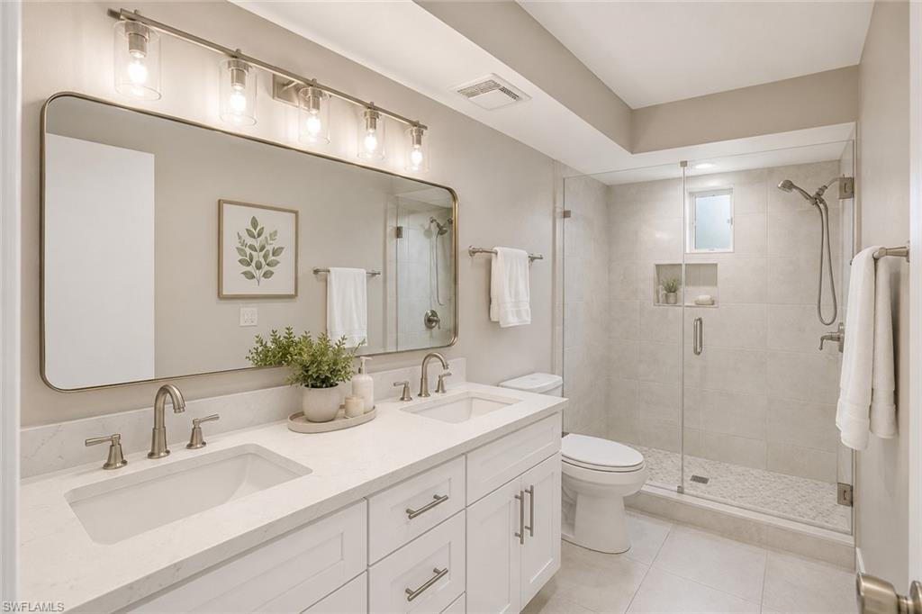 5290 Cypress Lane Naples, FL 34113 - Photo 21 of 39 a bathroom with a double vanity sink toilet and shower