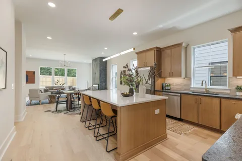 a kitchen with stainless steel appliances kitchen island granite countertop a refrigerator and a stove top oven
