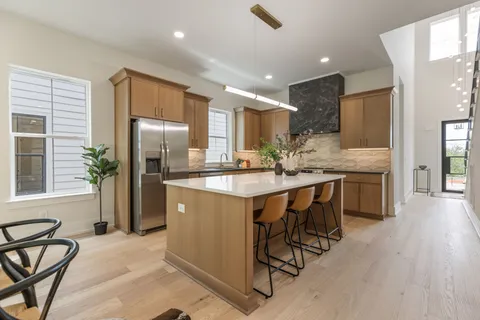 a kitchen with stainless steel appliances granite countertop a stove a sink and a white cabinets