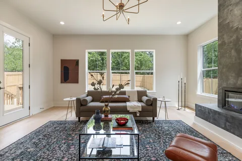a living room with furniture kitchen view and a chandelier