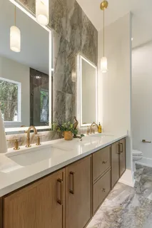a view of a hallway with wooden floor and a bathroom