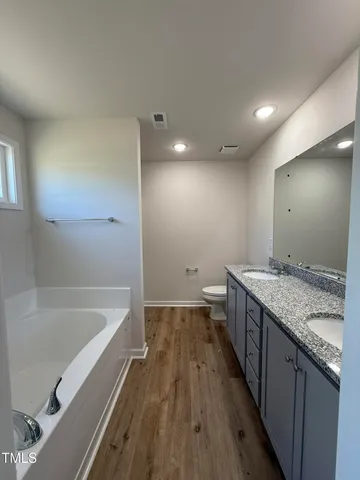 a bathroom with a granite countertop sink a toilet and bathtub