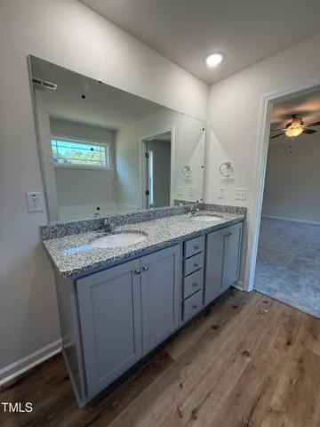 a bathroom with a granite countertop sink and a mirror