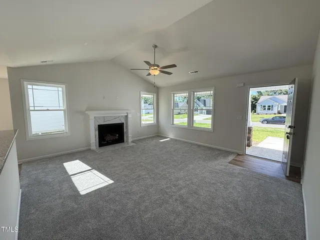 an empty room with windows and fireplace