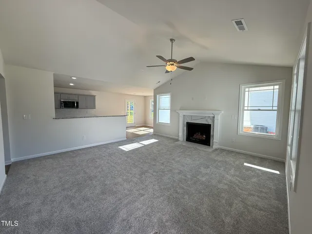 an empty room with windows and fireplace