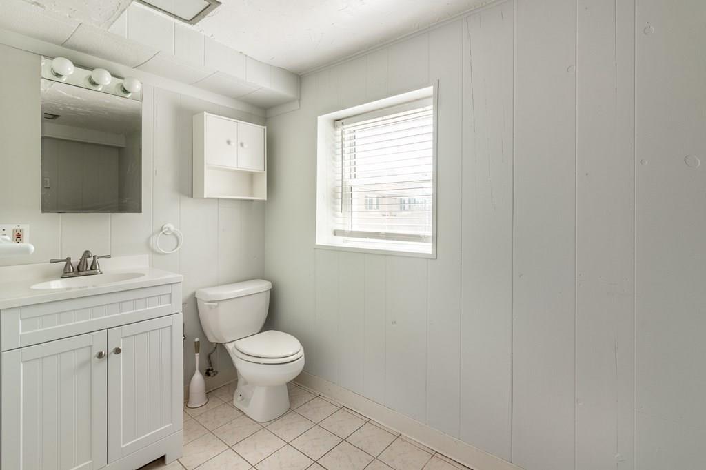 34 Brookline Avenue Hull, MA 02045 - Photo 28 of 40 a bathroom with a toilet a sink a mirror a window and vanity