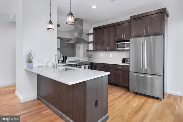a kitchen with kitchen island a sink stainless steel appliances and cabinets
