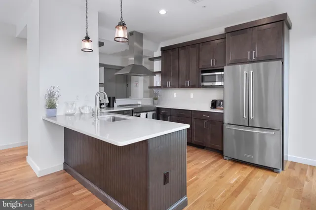 a kitchen with kitchen island a sink stainless steel appliances and cabinets