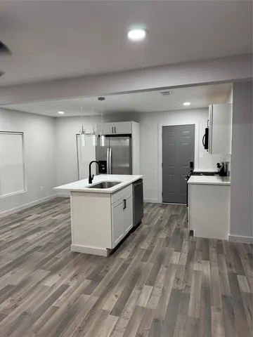 a kitchen with a refrigerator and a stove top oven