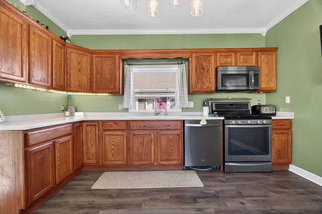a kitchen with stainless steel appliances granite countertop a stove a sink and a microwave