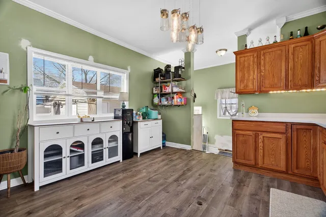 a kitchen with stainless steel appliances a stove top oven a refrigerator a sink dishwasher with wooden cabinets and floor