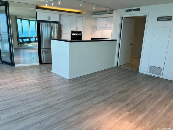 a view of a refrigerator in kitchen and wooden floor
