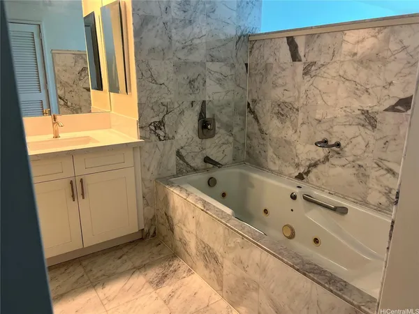 a bathroom with a tub a sink and a window