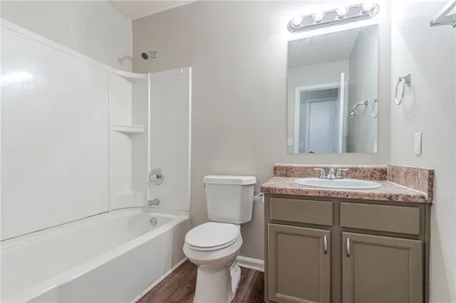 a bathroom with a granite countertop sink a toilet and bathtub